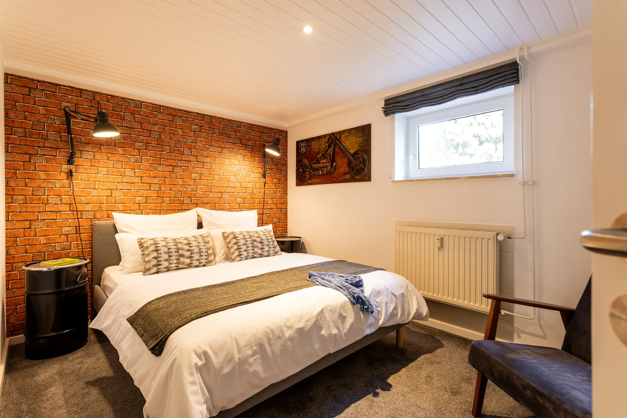 Schlafzimmer mit Boxspringbett und Backsteinwand